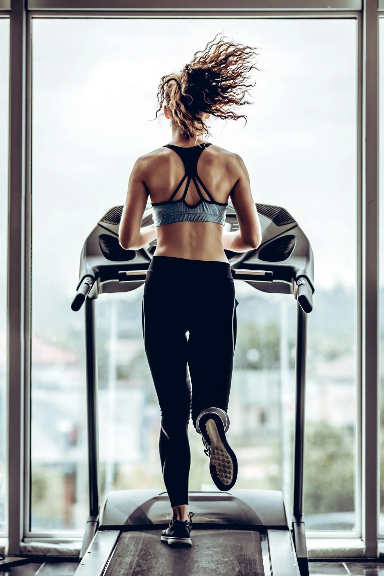 une femme court sur un tapis de course dans notre fitness à Collombey Muraz Valais